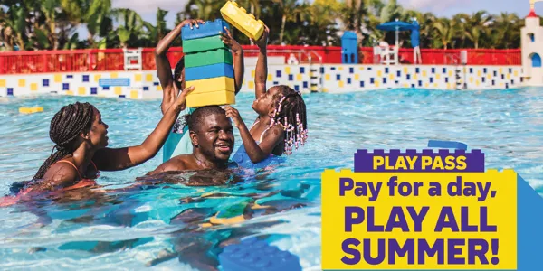Family stacking giant water LEGO bricks on dad's head at LEGOLAND Florida Water Park.