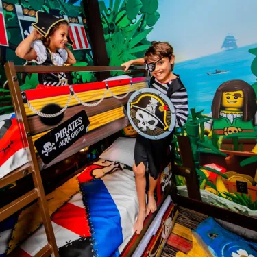 Two kids play pirates in their Pirate Island Hotel bunk beds.