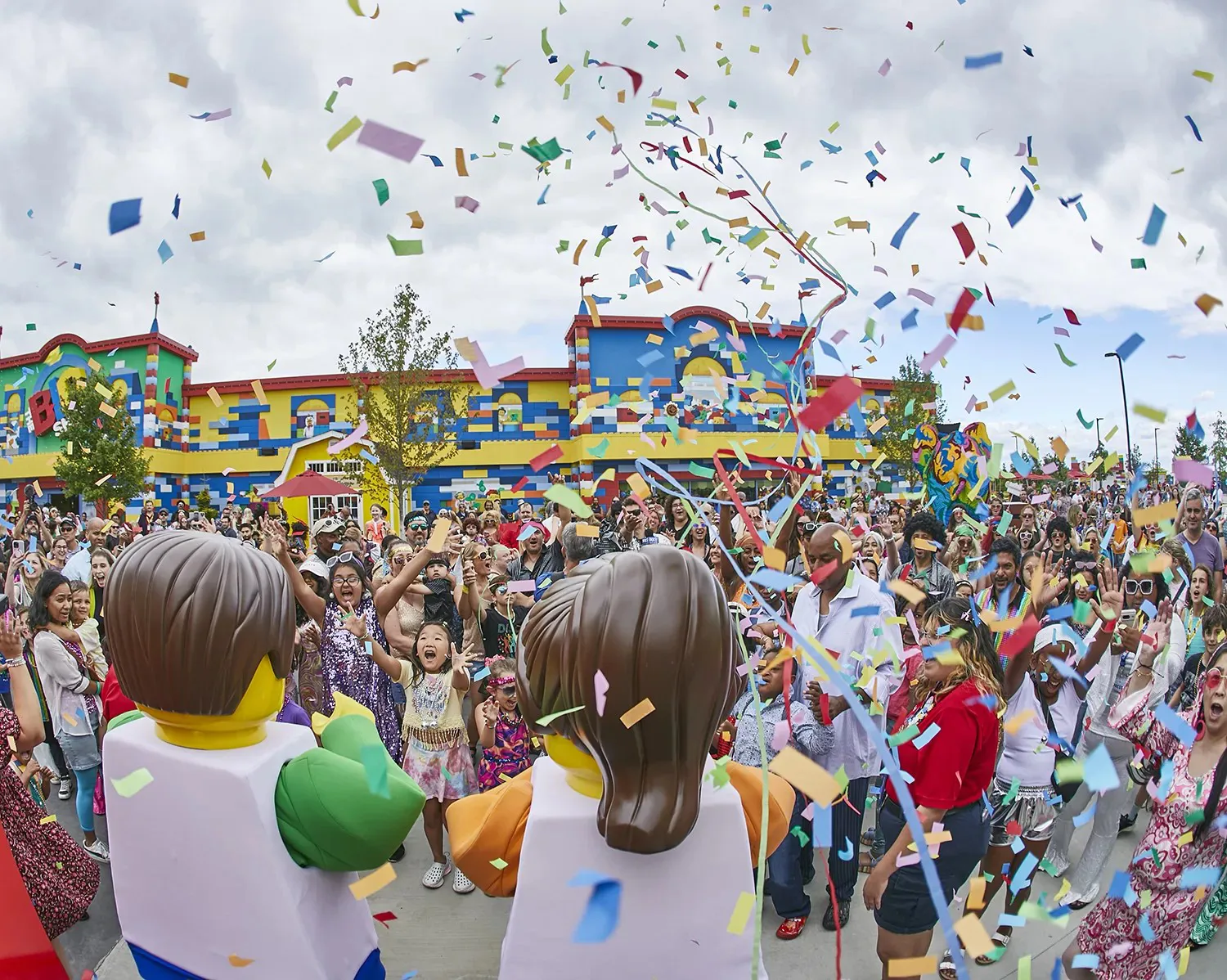 Crowd celebrates with confetti and LEGO characters at LEGO Festival in LEGOLAND Florida Resort.
